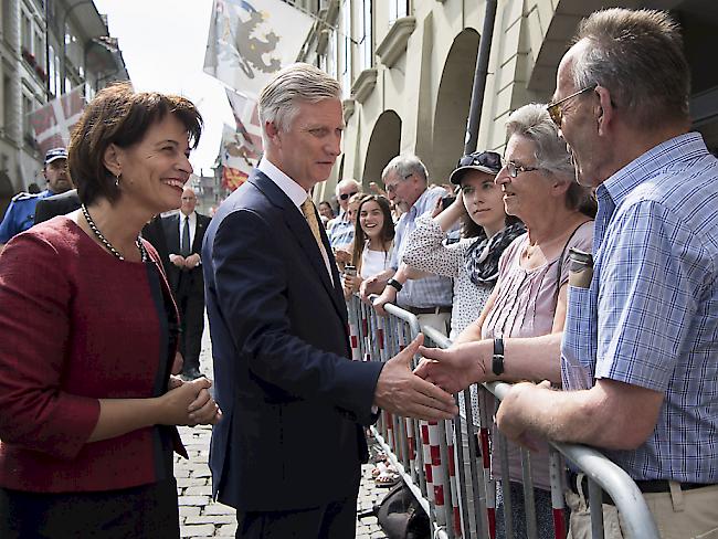 Bundespräsidentin Doris Leuthard (links) begrüsst zusammen mit dem König der Belgier Philippe (Mitte) Schaulustige in der Berner Münstergasse.