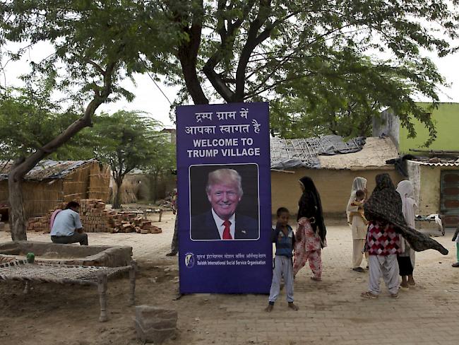 Am Ortseingang grüsst Trump als Strahlemann von einer Plakatwand. Darauf heisst es auf Hindu und Englisch "Willkommen im Trump-Dorf".