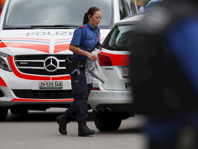 Nach dem Einsatz in Dübendorf wegen eines bewaffneten Mannes: Eine Kantonspolizistin bringt eine Waffe weg.
