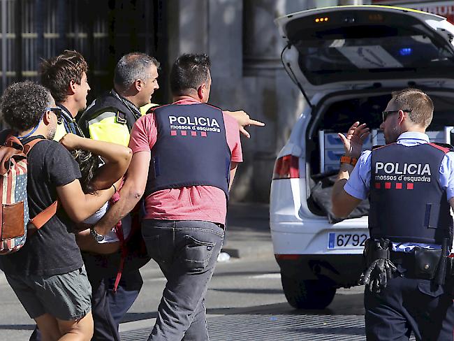 Polizei und Passanten tragen nach dem Anschlag in Barcelona eine verletzte Person