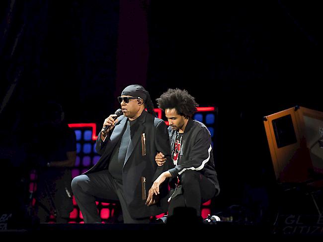 Stevie Wonder kniet gestützt von seinem Sohn auf der Bühne, um gegen US-Präsident Trump zu protestieren.