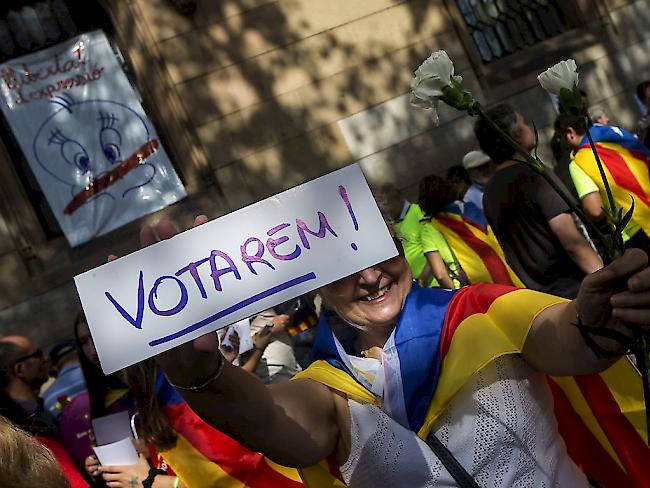 "Wir werden wählen" steht auf dem Schild dieser Demonstrantin in Barcelona. Damit dies geschehen kann, haben katalanische Separatisten Wahlzettel verteilt.