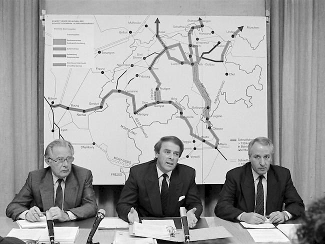 Bundesrat Adolf Ogi, Mitte, und Fritz Bürki, Direktor Bundesamt für Verkehr, links, präsentieren am 28. Mai 1990 in Bern die Botschaft über den Bau der Schweizerischen Eisenbahn-Alpentransversale NEAT. Am 27. September 1992 nahm das Stimmvolk den Beschluss mit 63,6 Prozent Ja-Stimmen an.
