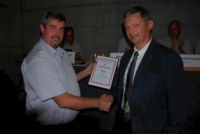 Der Präsident des Oberwalliser Feuerwehrverbands Guido Bregy (links) überreicht dem langjährigen Chef des Kantonalen Amts für Feuerwesen, Eric Senggen, die Urkunde zur Ehrenmitgliedschaft.