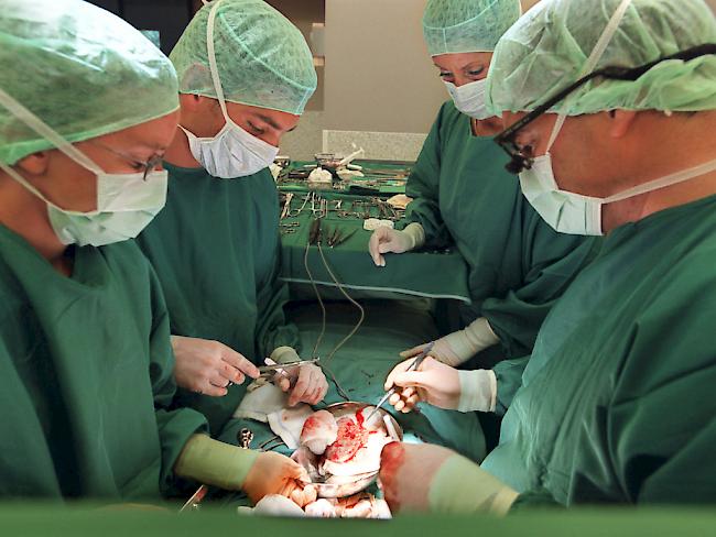 Ärzte implantieren einem Patienten eine Niere. (Archivbild)