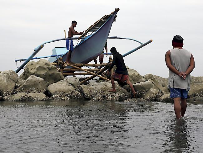 Fischer sichern ein Boot vor der Ankunft des Sturms.