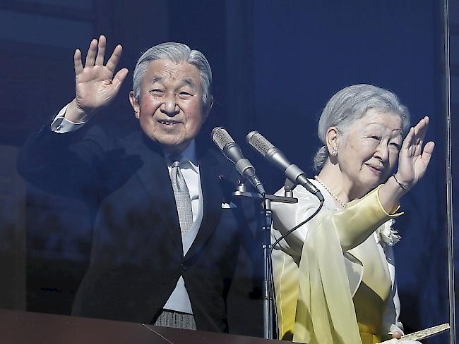 Kaiser Akihito und Kaiserin Michiko winken ihren Anhängern zu.