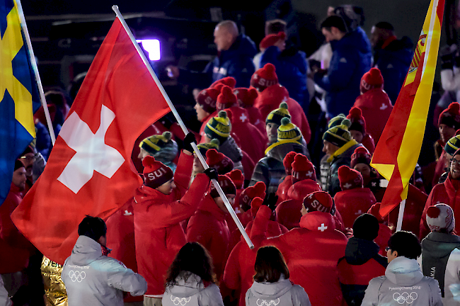 Ramon Zenhäusern trägt an der Schlussfeier die Schweizer Fahne.