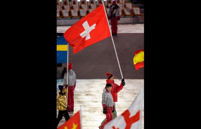 Ramon Zenhäusern trägt an der Schlussfeier die Schweizer Fahne.