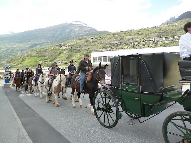 Pferde und Reiter ziehen durch die Kleegärten Richtung Pfarrkirche.