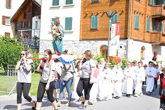 Jugendliche tragen eine Statue der heiligen Jungfrau Maria durchs Dorf.