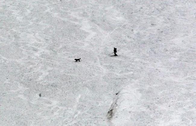 Ein Retter überquert mit seinem Suchhund einen Lawinenhang (Archiv)
