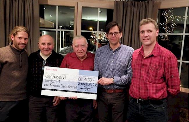 Mitglieder des Kiwanis Club Zermatt übergeben einen Check an Tandem-91-Präsident Amandus Meichtry (Mitte).