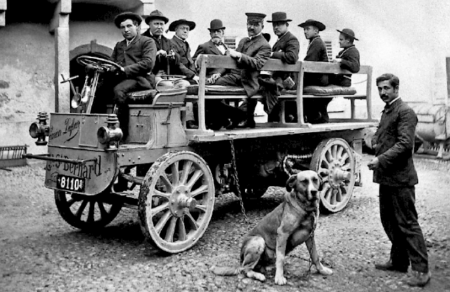Im Jahr 1905 erreicht ein erster Lastkraftwagen der Marke Dufour das Hospiz des grossen St. Bernhard. Zur offiziellen Einweihung steigen Persönlichkeiten auf die harte Ladebrücke.