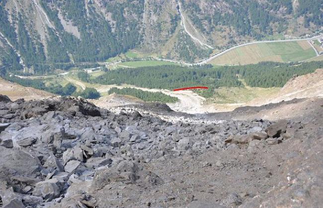 Blick vom Geröllfeld auf 3000 Meter hinunter ins Tal. Die rote Linie markiert den Ort des Dammbaus. 