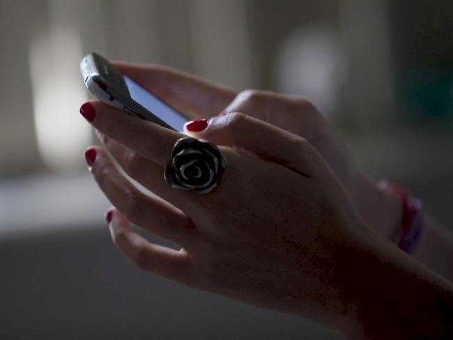 Eine Frau schreibt eine Nachricht mit ihrem Handy (Symbolbild)