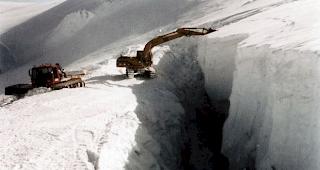 Ein Bagger sch&uuml;ttet eine Gletscherspalte im Sommerskigebiet von Zermatt zu