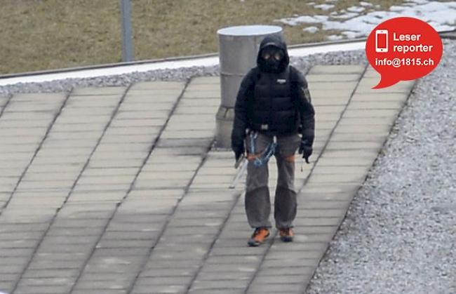 Mit Gasmaske verkleidet und einem Gewehr in der Hand. 