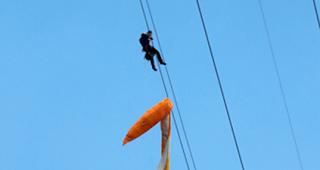 Der unverletzte Gleitschirmpilot in seiner misslichen Lage. Ein Rettungsspezialist der Air Zermatt eilt zu Hilfe.