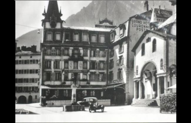 Der Sebastiansplatz in Brig, der Brunnen steht noch an seinem ursprünglichen (richtigen) Ort. Das Haus dahinter steht nicht mehr. Da befindet sich jetzt die Treppe von der UBS. Kutschen gib's hier wohl auch nicht mehr.