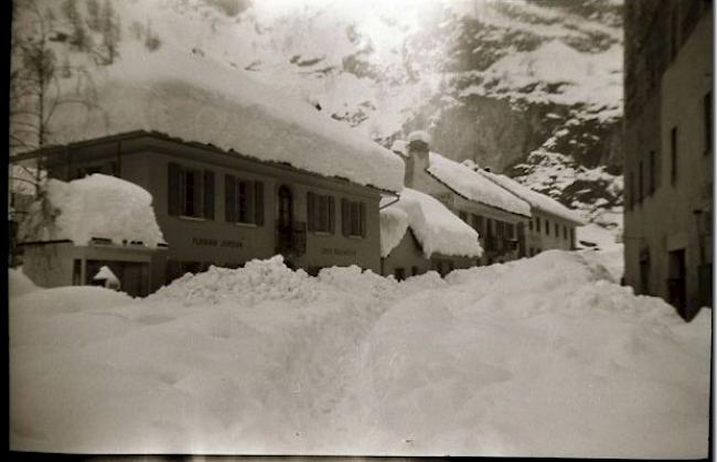 Hochwinter in Gondo ca. 1955. Der Helikopter brachte Post und Lebenswichtiges, konnte aber nirgends landen und warf die Fracht einfach ab. Die ABC-Schüler wurden auf den Schultern der Väter zur Schule getragen...