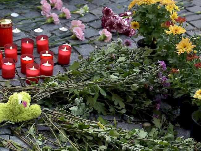 Blumen und Kerzen vor der Polizeidirektion Eisenstadt im österreichischen Burgenland zum Gedenken an die in einem Lastwagen gefundenen toten Flüchtlinge.