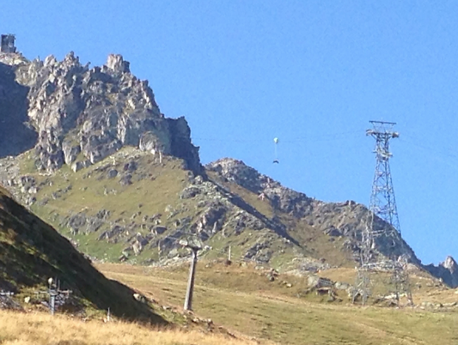 Ein Gleitschirmpilot hängt im Rettungsschirm am Seil der Luftseilbahn Kühboden-Eggishorn.