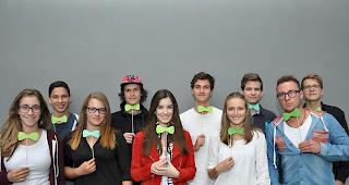 Fliege gemacht. Schüler des Ergänzungsfach Geschichte mimen den Politologen Claude Longchamp, auch bekannt für seine Kravatten. Hintere Reihe (v.l.) Sebastian Schmid, Beda Johannes Henzen, Lukas Bertholjotti, Xavier Radmann, Matthias Venetz. Vorne (v.l.). Florane Pralong, Lena Maria Seematter, Ilijana Eyer, Kimberly Breuer, Cy-Roberto Schmidt. (Lehrer: Matthias Schmidhalter)