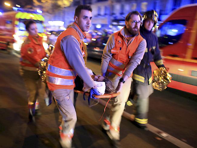 Rettungskräfte bergen eine Frau nach der Geiselnahme im Konzertsaal "Bataclan" in Paris. Bei mehreren Anschlägen wurden mehr als 200 Personen verletzt.