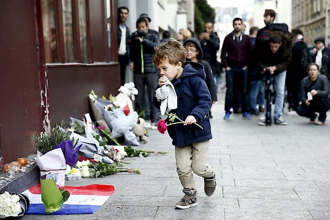 Trauer in Paris: Ein Kind legt Blumen nieder.