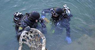Clean Up Day in Siders: Taucher der SLRG Oberwallis ziehen bei der S&auml;uberungsaktion im Gerundensee einen Stuhl an Land.
