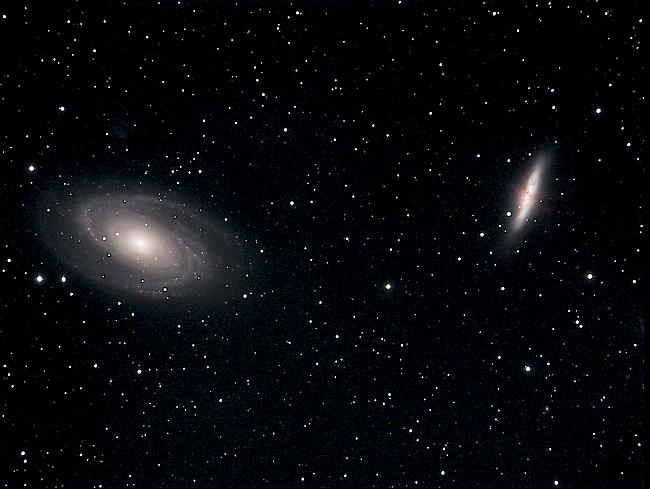 Die M81-Gruppe (Distanz zur Erde: Rund 12 Millionen Lichtjahre): Die bekanntesten Mitglieder der M81-Gruppe sind die beiden Galaxien M81 und M82. Das Objekt M81 (links im Bild) ist eine Spiralgalaxie von ovaler Struktur, die viele Sterne in ihrem hellen Zentrum aufweist. Das ausgedehnte Galaxiezentrum ist möglicherweise auf ein enorm grosses Schwarzes Loch zurückzuführen. Mit schätzungsweise 200 Milliarden Sternen ist das System etwas kleiner als die Milchstrasse. M81 umfasst eine Vielzahl von Mitgliedsgalaxien. In ihrer direkten Nähe (150