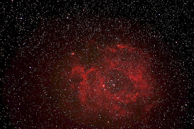 Der Rosettennebel (Distanz zur Erde: 5000 Lichtjahre): Der Rosettennebel ist ein diffuser Emissionsnebel aus interstellarem Gas im Sternbild Einhorn, in dessen Zentrum ein offener Sternhaufen mit heissen und jungen Sternen eingebettet ist. Die Sterne im energiereichen Haufen, welche den Nebel zum Leuchten bringen, sind nur wenige Millionen Jahre alt. Der zentrale Hohlraum im Rossettennebel weist einen Durchmesser von etwa 50 Lichtjahren auf. Seinen Namen bekam der Nebel durch sein Aussehen, das an den Blütenkelch einer Rose erinnert.