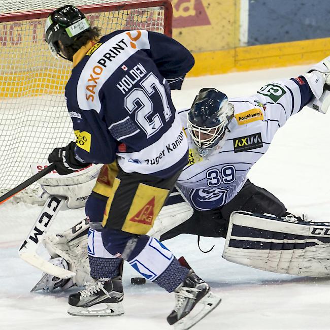 Ambri-Hüter Sandro Zurkirchen wehrt gegen Zugs Josh Holden