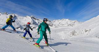 Eine Familie beim Skifahren in der Aletsch Arena.