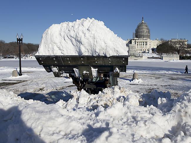 Eine Maschine lädt Schnee vor dem Kapitol in Washington ab.