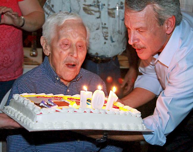 «Ted Mullers 107. Geburtstag. Sein Sohn reicht ihm den Kuchen, damit er die Kerzen ausblasen kann.»
