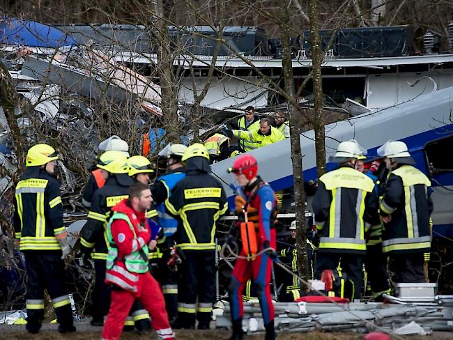 Rettungskräfte sind am Unfallort bei Bad Aibling im Einsatz. Bei der Frontalkollision zweier Züge sind am Dienstagmorgen mehrere Menschen ums Leben gekommen