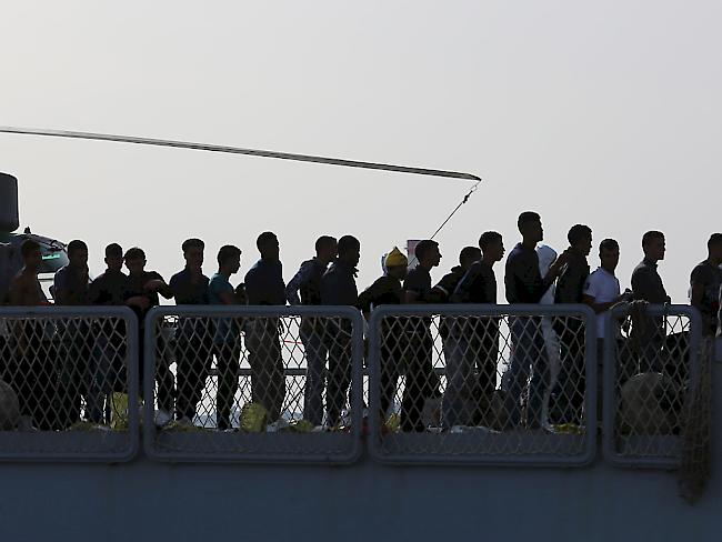 EU-Kommission will Fluchtursachen bekämpfen: Migranten und Flüchtlinge verlassen ein italienisches Schiff in Sizilien (Archiv).
