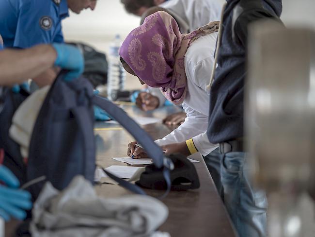 Flüchtlinge und Grenzwächter bei der Kontrolle am Bahnhof in Chiasso TI (Archiv).