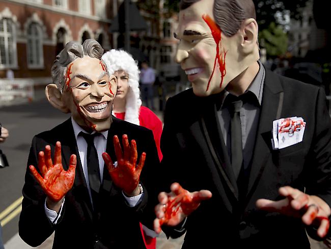 Demonstranten mit "Blut" an den Händen und Masken von Tony Blair (l) und dem früheren US-Präsidenten George W. Bush in London anlässlich der Veröffentlichung des Chilcot-Berichts