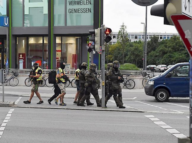 Nach der Schiesserei mit mehreren Toten in einem Shoppingcenter in München patrouillieren Spezialeinheiten der Polizei vor dem Gebäude.