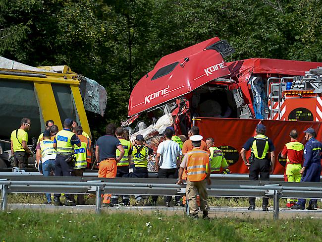 Dazwischen steckt ein zerdrücktes Auto: Der eine Lastwagen ist mit Granit, der andere mit Wasser beladen, was die Bergung äusserst schwierig macht.
