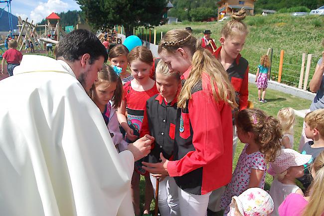 Pfarrer Raphael Kronig weiht den Platz gemeinsam mit den Kindern ein.