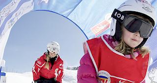 Ein Kind macht mit einer Skilehrerin erste Erfahrungen auf Skiern.