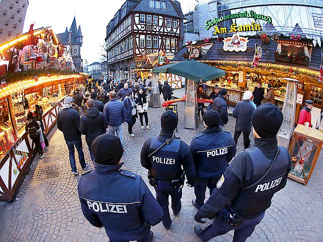 Schwer bewaffnete Polizisten bewachen einen Weihnachtsmarkt in Frankfurt. In ganz Europa wird fieberhaft nach dem Tatverdächtigen von Berlin gesucht.
