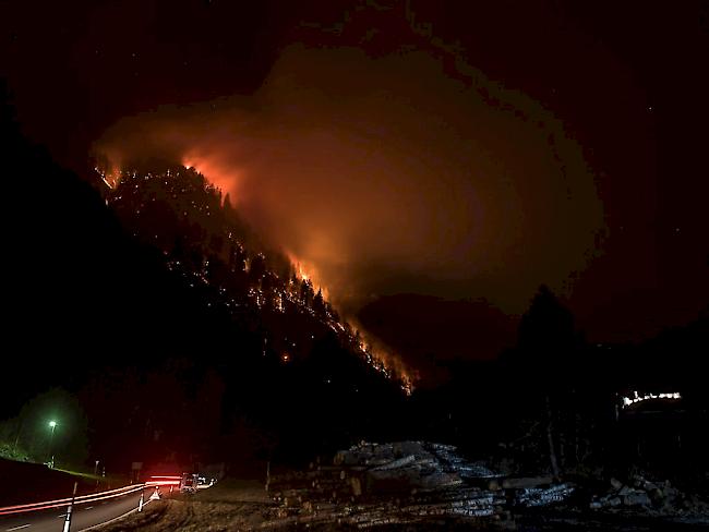 Dunkelheit und Wind machen die Löscharbeiten für die Feuerwehrleute schwierig: Waldbrand im Misox zwischen Mesocco und Soazza.