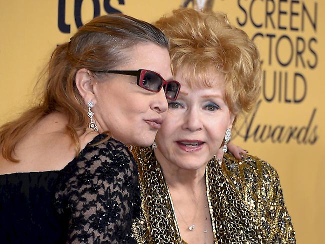 Debbie Reynolds (rechts) soll einen Tag nach dem Tod ihrer Tochter Carrie Fisher (links) einen Schlaganfall erlitten haben. (Archivbild)