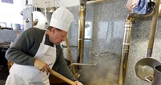 Anger&uuml;hrt. Die Polenta wird in den Gussh&auml;fen &uuml;ber dem Holzfeuer kr&auml;ftig anger&uuml;hrt.