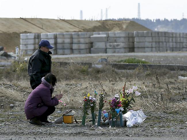 Eine Frau und ein Mann gedenken ihrer Tochter, die nach der Erdbeben- und Tsunamikatastrophe bei Fukushima vor sechs Jahren gestorben ist.